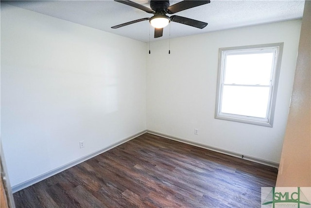 empty room featuring dark wood-style flooring and baseboards