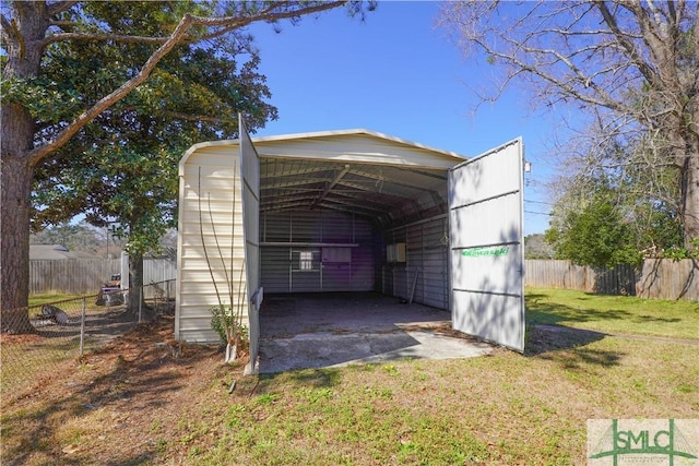 view of outbuilding featuring a carport and fence