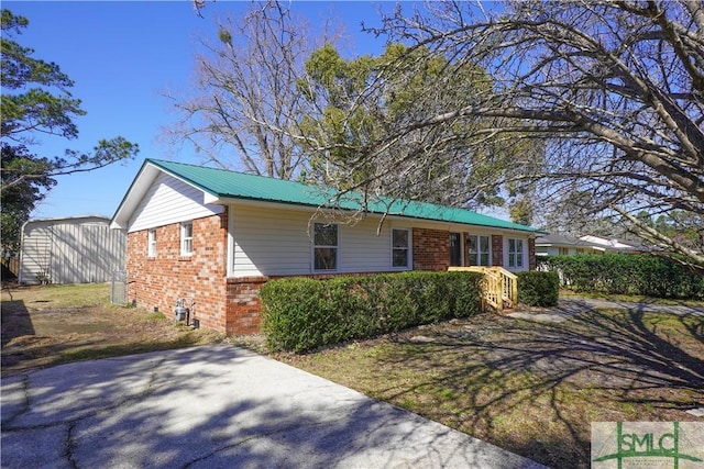 view of front of property with metal roof and brick siding