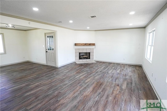 unfurnished living room featuring a textured ceiling, a fireplace, visible vents, and dark wood-type flooring