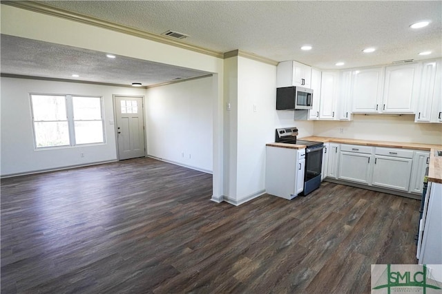 kitchen with visible vents, white cabinets, open floor plan, wooden counters, and appliances with stainless steel finishes