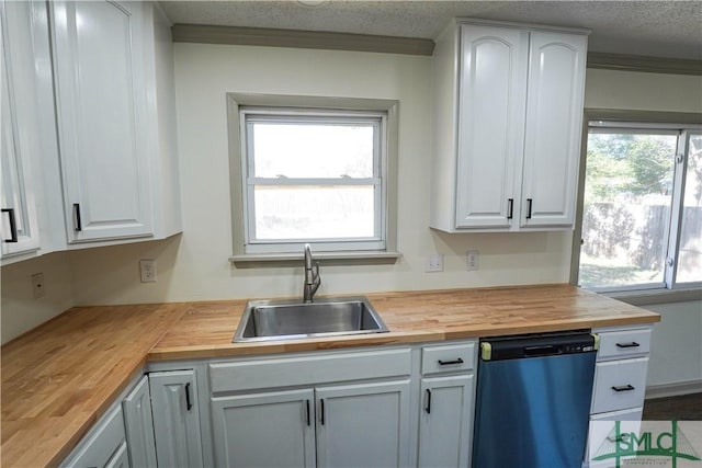 kitchen with white cabinetry, dishwasher, wood counters, and a sink