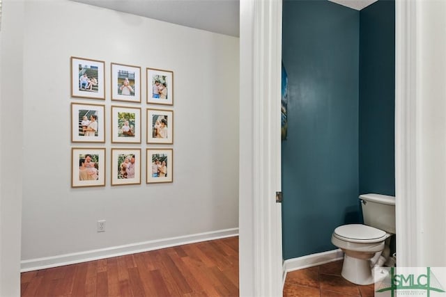 bathroom featuring baseboards, toilet, and wood finished floors