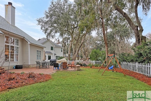 view of yard with a patio area, a fenced backyard, and a playground