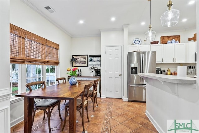 kitchen with white cabinetry, light countertops, ornamental molding, hanging light fixtures, and stainless steel fridge