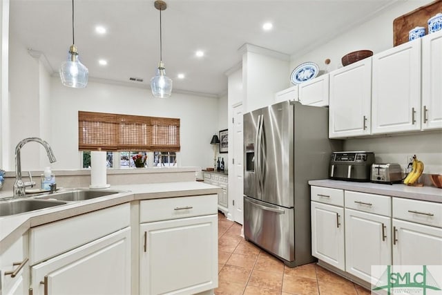 kitchen with light countertops, stainless steel fridge, decorative light fixtures, and white cabinets