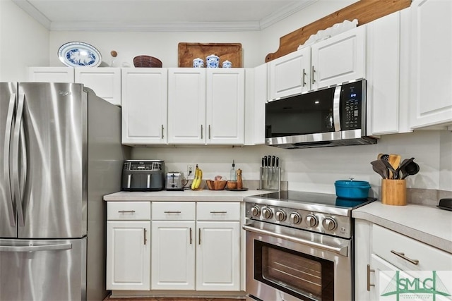 kitchen with appliances with stainless steel finishes, light countertops, white cabinetry, and ornamental molding