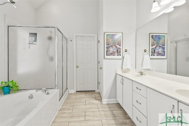 bathroom featuring double vanity, a stall shower, a garden tub, and a sink