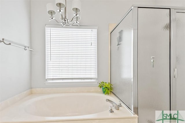 bathroom with a shower stall, a bath, and an inviting chandelier