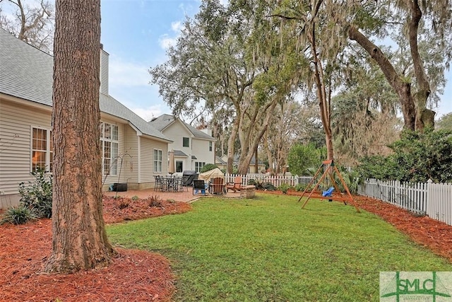 view of yard with a patio area, a fenced backyard, and a playground