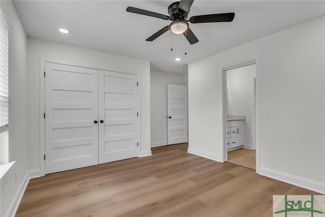 unfurnished bedroom featuring baseboards, ensuite bath, light wood-style floors, a closet, and recessed lighting