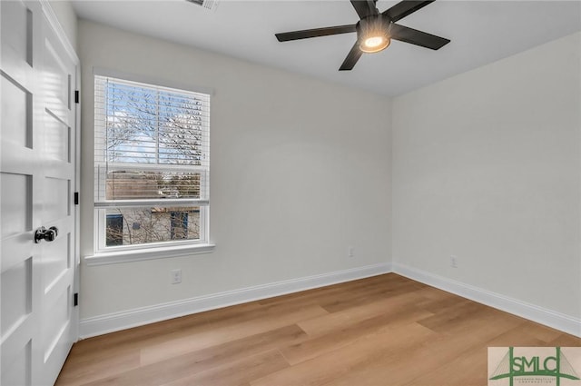 unfurnished room with a ceiling fan, light wood-style flooring, and baseboards