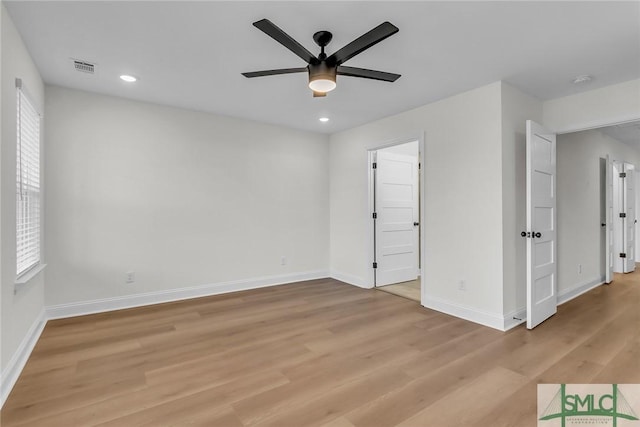 unfurnished bedroom with light wood-type flooring, multiple windows, baseboards, and recessed lighting