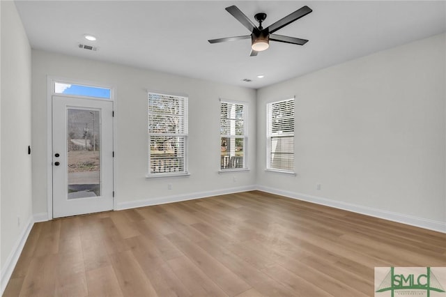 interior space featuring light wood-style flooring, visible vents, baseboards, and a wealth of natural light