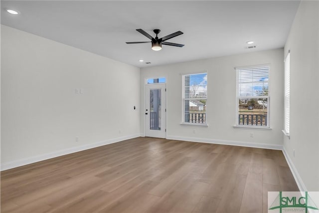 unfurnished room with light wood finished floors, visible vents, and baseboards