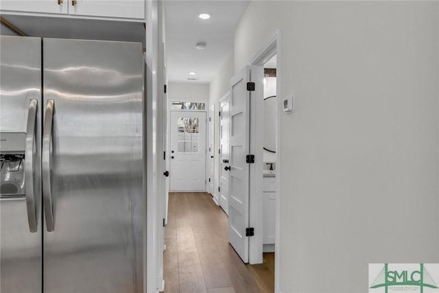 kitchen with white cabinets, light wood-style flooring, stainless steel refrigerator with ice dispenser, and recessed lighting