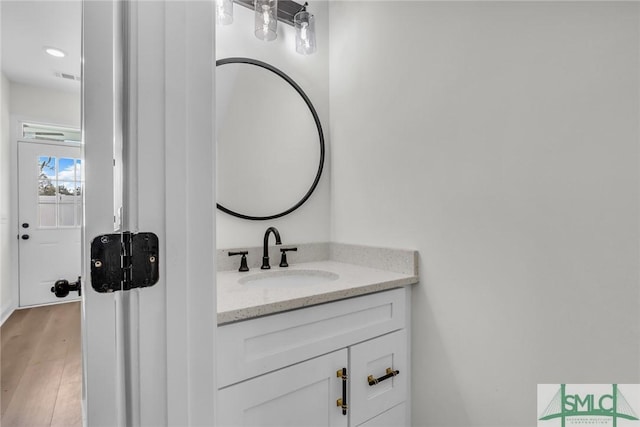 bathroom featuring visible vents, wood finished floors, and vanity