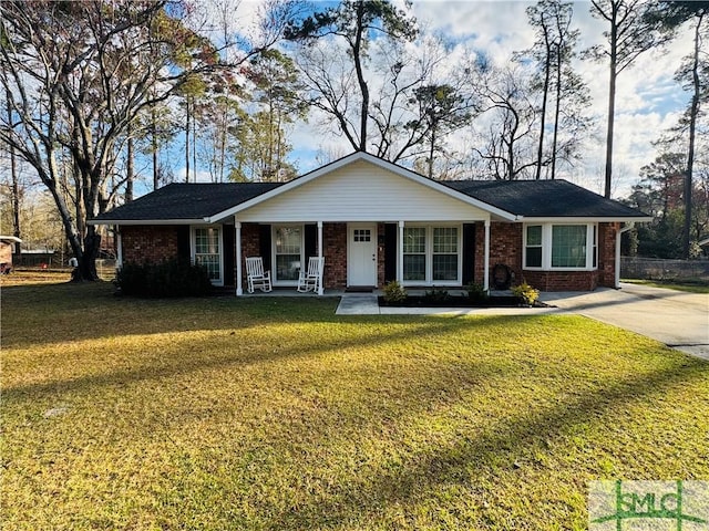 ranch-style house featuring covered porch, brick siding, and a front yard