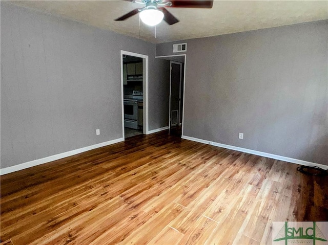 interior space featuring baseboards, ceiling fan, visible vents, and wood finished floors