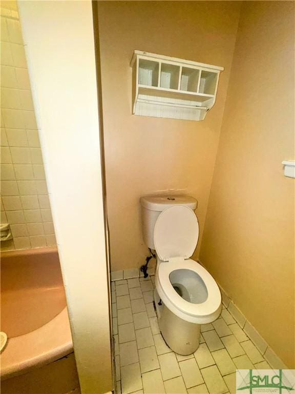 bathroom featuring toilet and baseboards