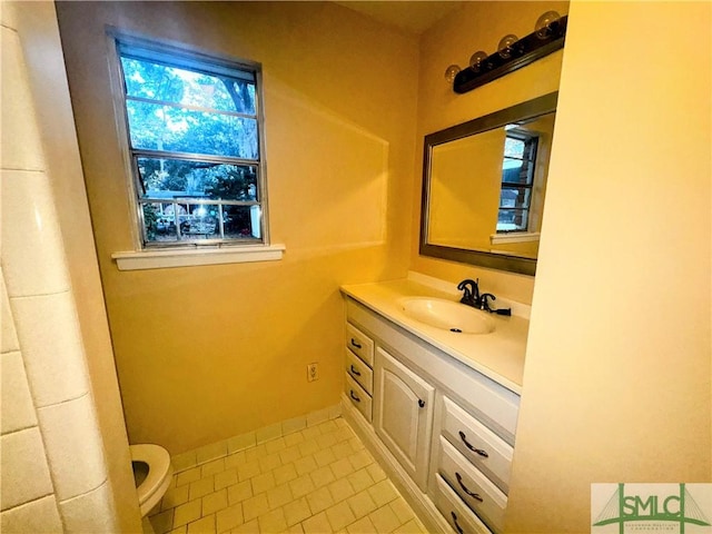 bathroom with toilet, tile patterned flooring, and vanity