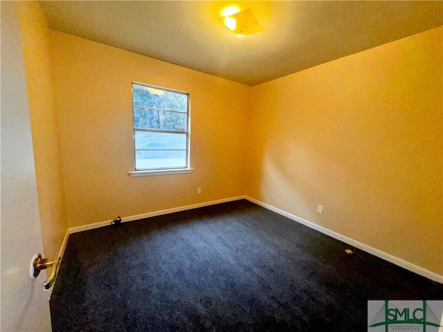 carpeted spare room featuring baseboards