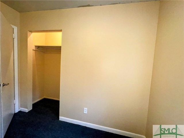 unfurnished bedroom featuring baseboards and dark colored carpet