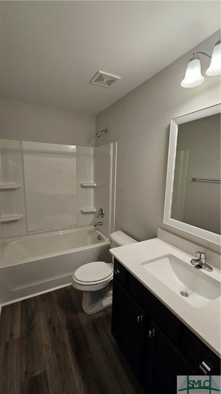 full bath with visible vents, shower / bathing tub combination, toilet, vanity, and wood finished floors