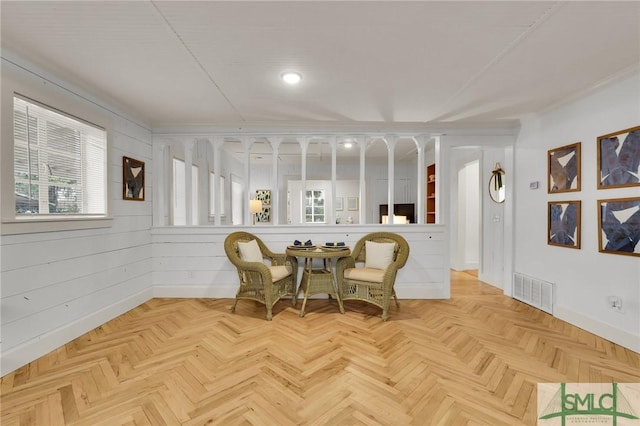 living area with baseboards and visible vents