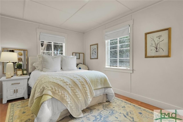 bedroom with baseboards and wood finished floors