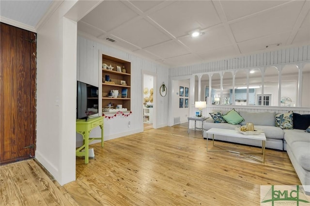 living area featuring built in features, coffered ceiling, visible vents, and wood finished floors