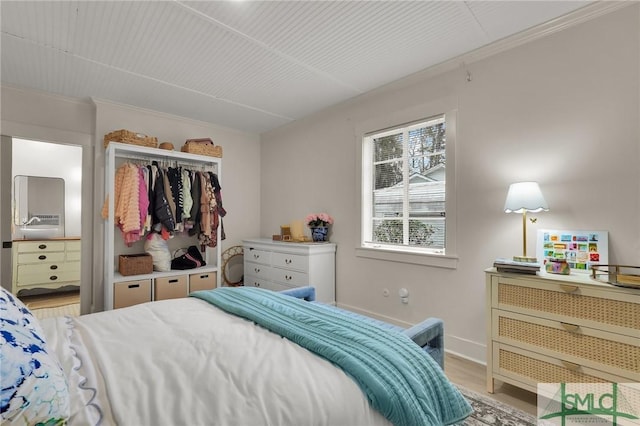 bedroom featuring ornamental molding, a closet, baseboards, and light wood finished floors