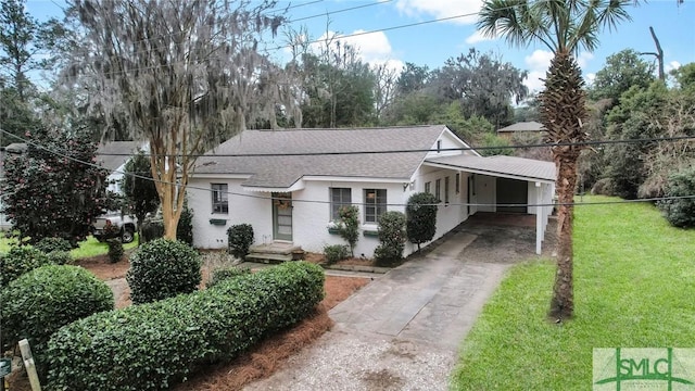 view of front of house with roof with shingles, stucco siding, a carport, driveway, and a front lawn