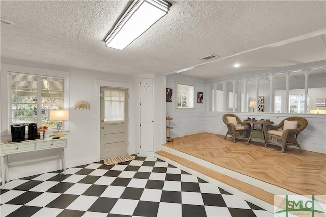 interior space featuring dark floors, visible vents, and a textured ceiling