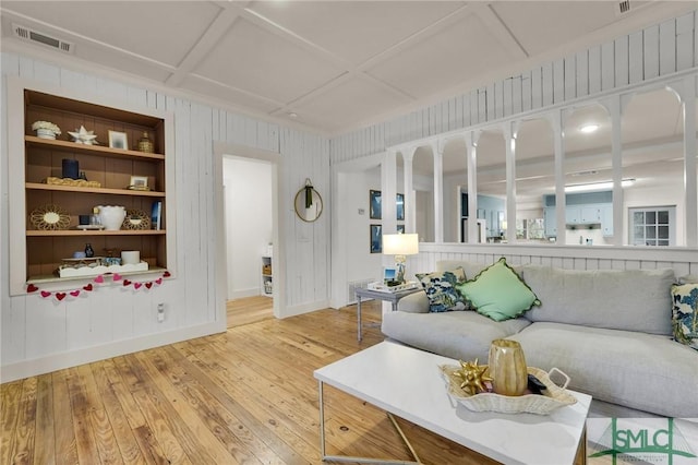 living area featuring baseboards, visible vents, coffered ceiling, wood finished floors, and built in shelves