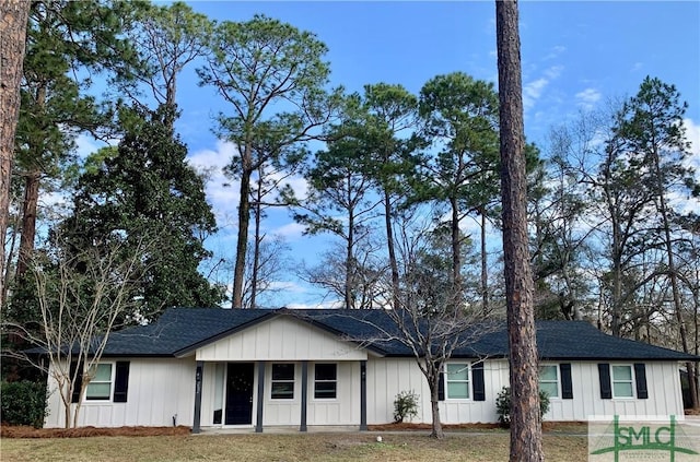 ranch-style home featuring a shingled roof, board and batten siding, and a front yard