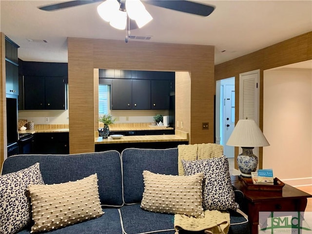 living area featuring a ceiling fan and visible vents