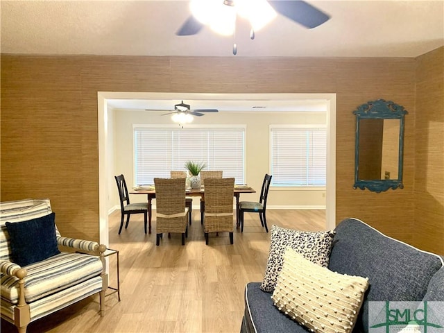 dining space featuring ceiling fan, light wood-type flooring, and baseboards