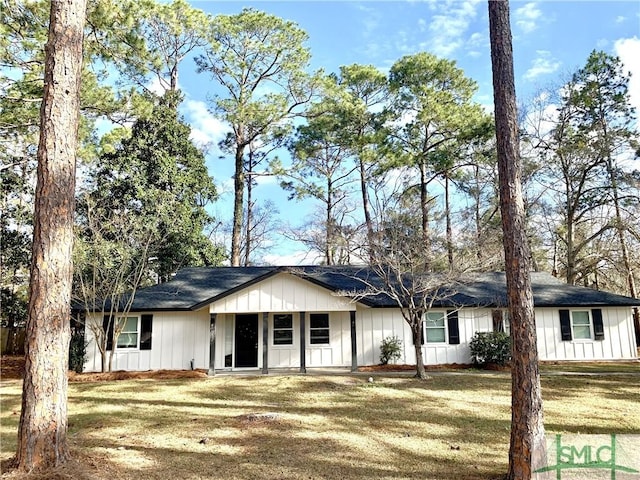 single story home with board and batten siding and a front yard