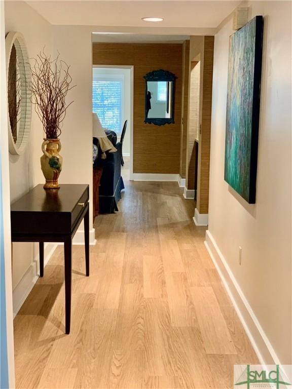 hall with baseboards and light wood-style floors