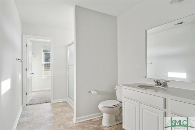 bathroom featuring toilet, visible vents, vanity, baseboards, and a stall shower