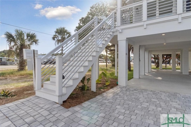 view of patio / terrace with stairs, a carport, and decorative driveway