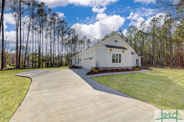 view of front of property with an attached garage, driveway, and a front lawn