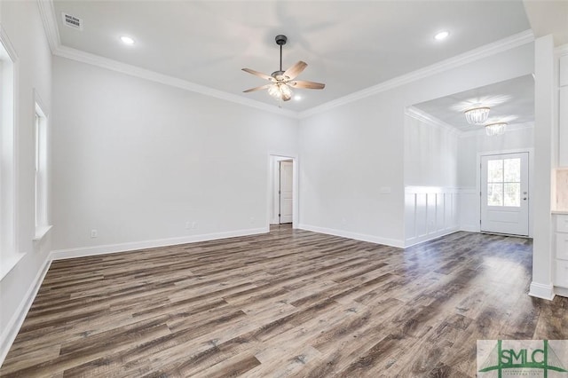 spare room with visible vents, ornamental molding, wood finished floors, and ceiling fan with notable chandelier