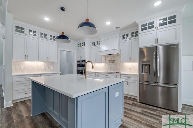 kitchen featuring appliances with stainless steel finishes, light countertops, custom range hood, and glass insert cabinets