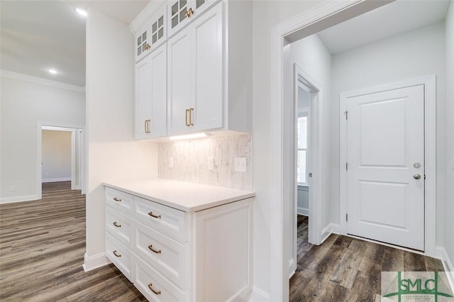 kitchen featuring light countertops, dark wood-style flooring, glass insert cabinets, and white cabinets