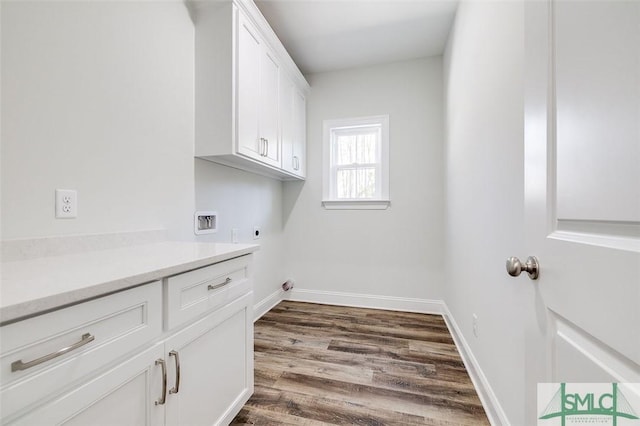 clothes washing area featuring hookup for an electric dryer, washer hookup, baseboards, cabinet space, and dark wood-style floors