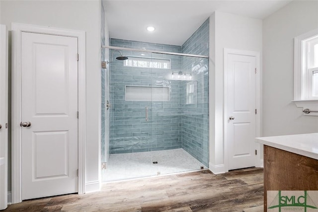 bathroom with a shower stall, vanity, and wood finished floors