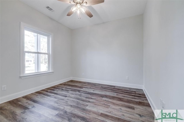 empty room with visible vents, dark wood finished floors, baseboards, and ceiling fan