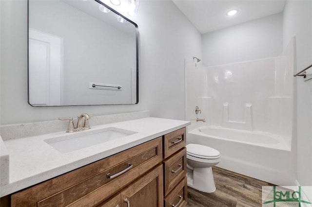 full bathroom featuring toilet, bathtub / shower combination, wood finished floors, and vanity